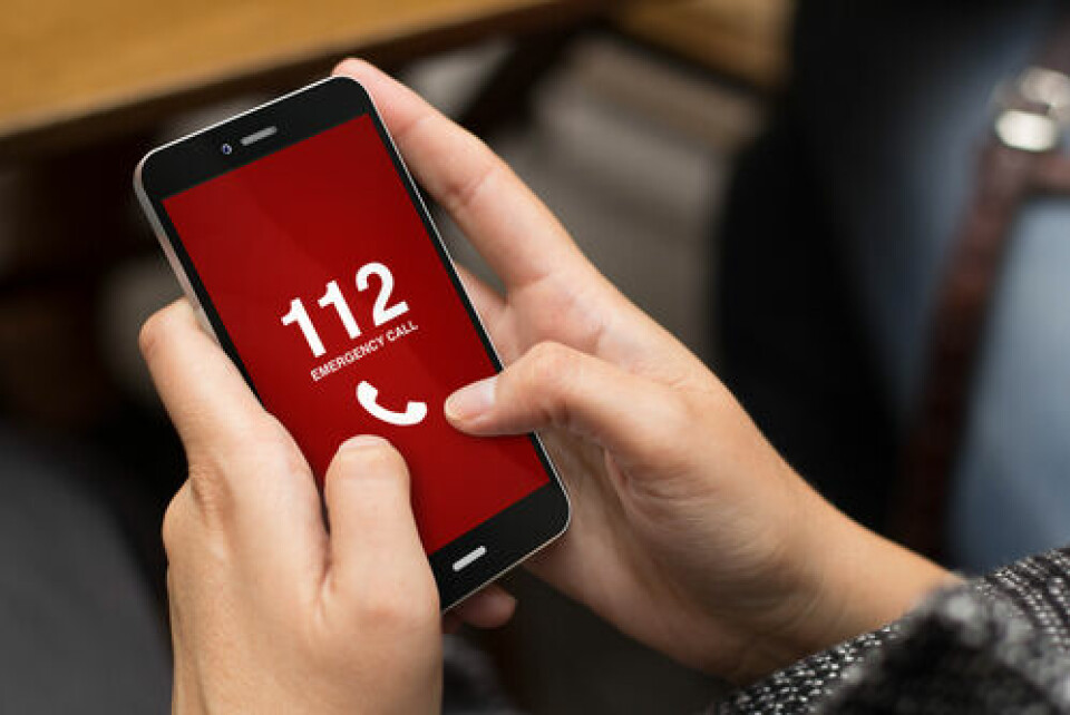 A woman holds a phone reading 112 emergency number. Making 112 the only emergency number in France would be ‘an error’
