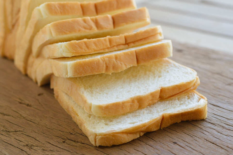 Forstbreath / Shutterstock A sliced white loaf on a wooden countertop.
