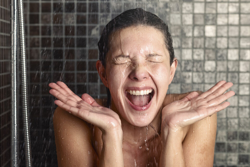 Young woman reacting in shock to cold shower water. Hot weather continues in France: 10 things not to do in a heatwave