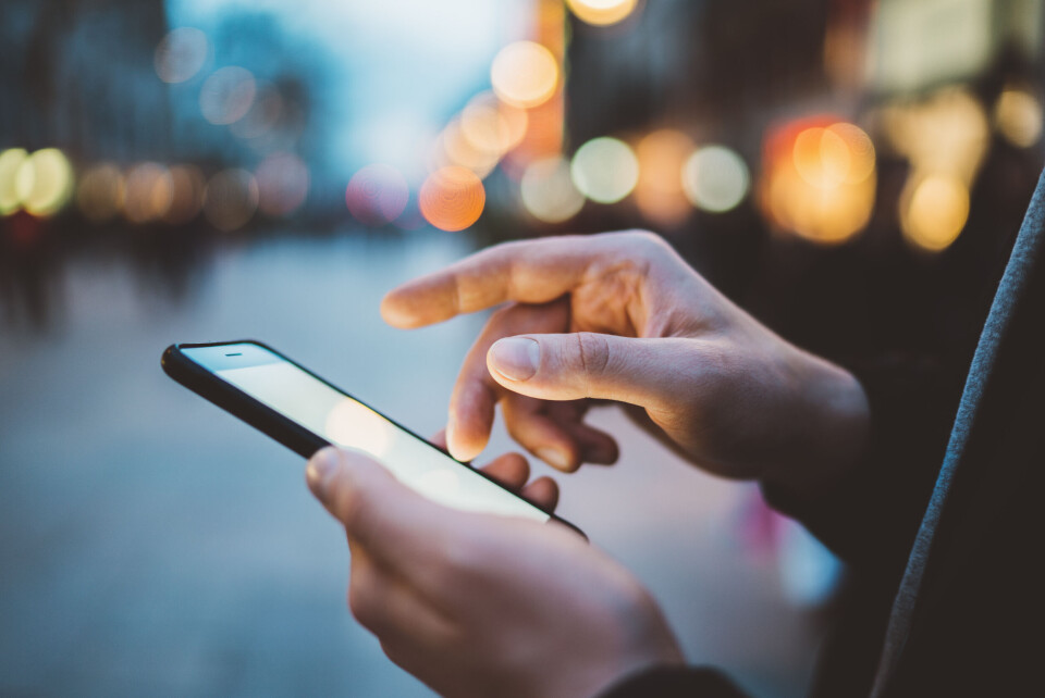 Closeup of male hands using modern smartphone with blank screen