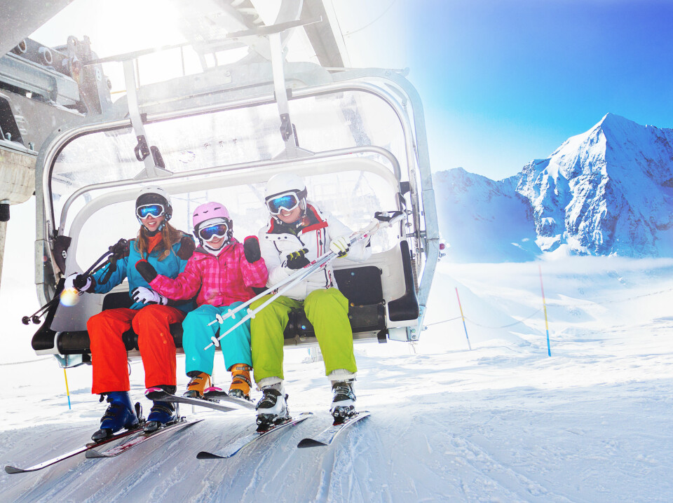 Skiers take a ski lift up the mountain