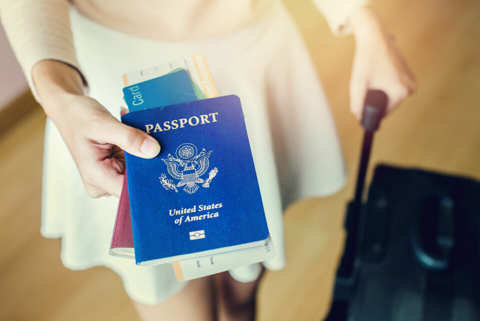 A person with a suitcase holding a US passport