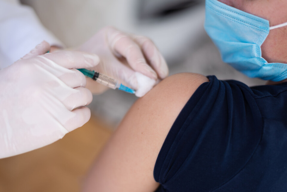 As-artmedia / Shutterstock A person wearing a mask, receiving an injection.