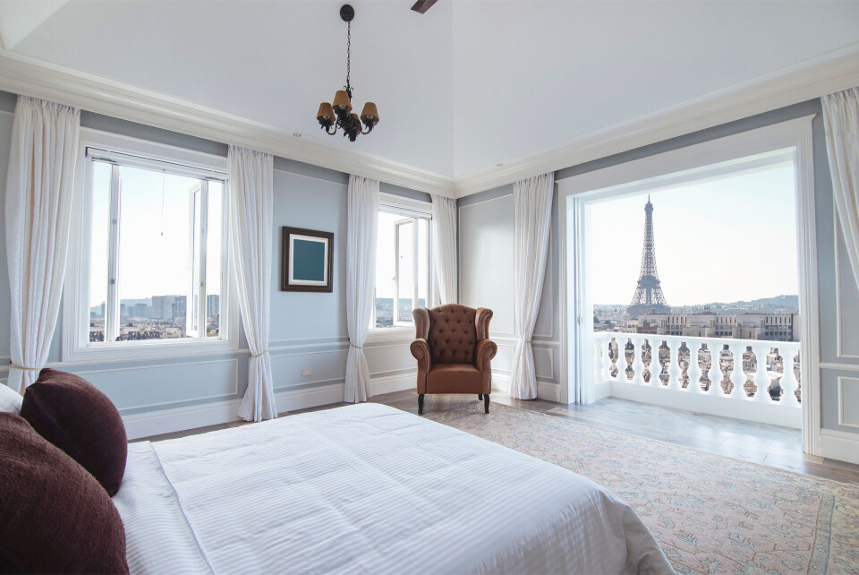 MDV Edwards / Shutterstock A modern apartment bedroom looking out on a view of the Eiffel Tower in Paris