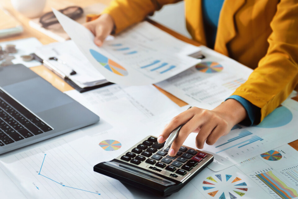 lovelyday12 / Shutterstock An image of a person working on accounts and spreadsheets with a calculator in hand