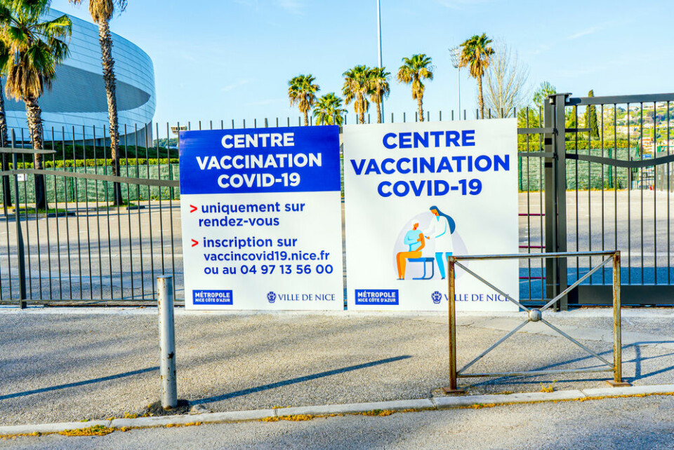 Signs to a vaccination centre in Nice, with palm trees visible behind. France allows holidaymakers to get second Covid jab while away