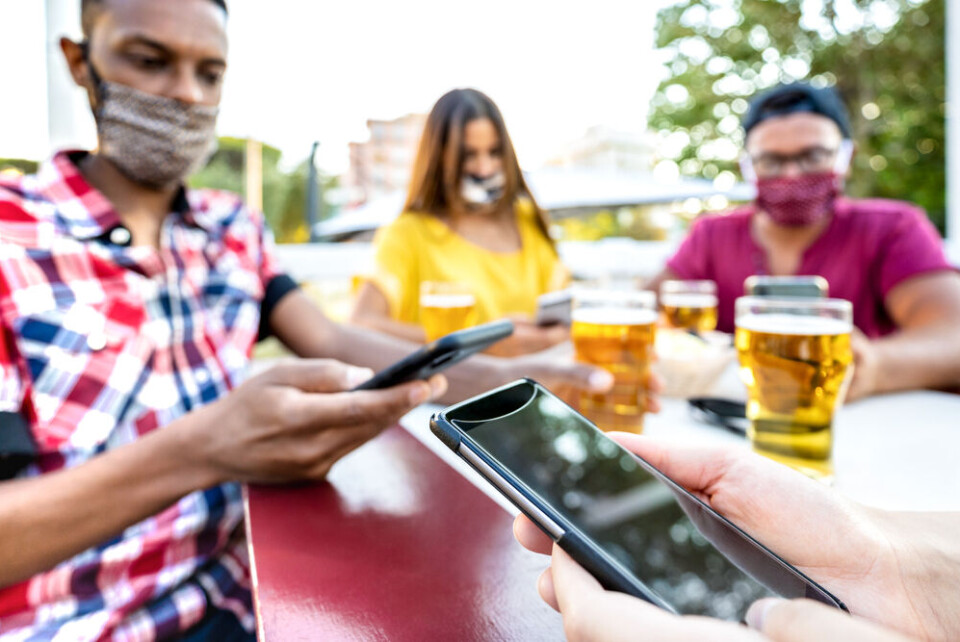 View Apart / Shutterstock People using their phones in a bar. Covid-19 France: How does backwards contact tracing work?