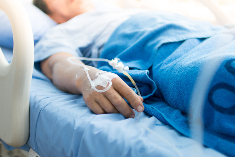 A close-up of the hand of a hospital patient in bed.