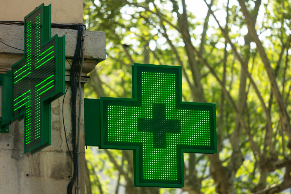 Green cross pharmacy sign. Covid France: People urged to use vaccine appointments in pharmacies