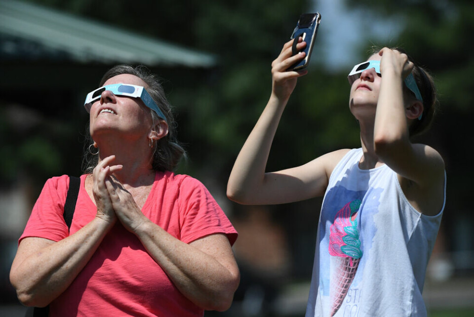 Women look into the sun using solar eclipse glasses. Partial eclipse of the Sun visible in France this week: How to watch