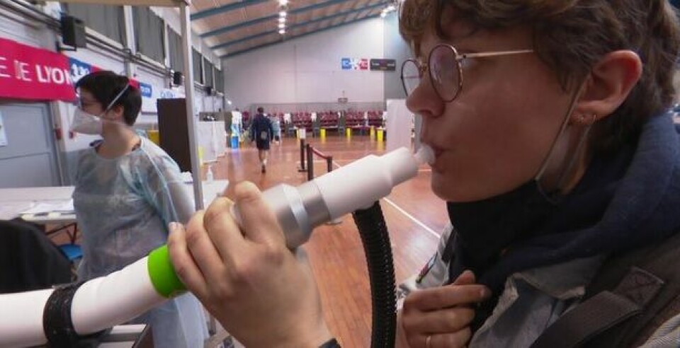 A woman breathes into the Covid-Air machine. Covid-Air: Super-fast Covid test using exhaled air trialled in Lyon