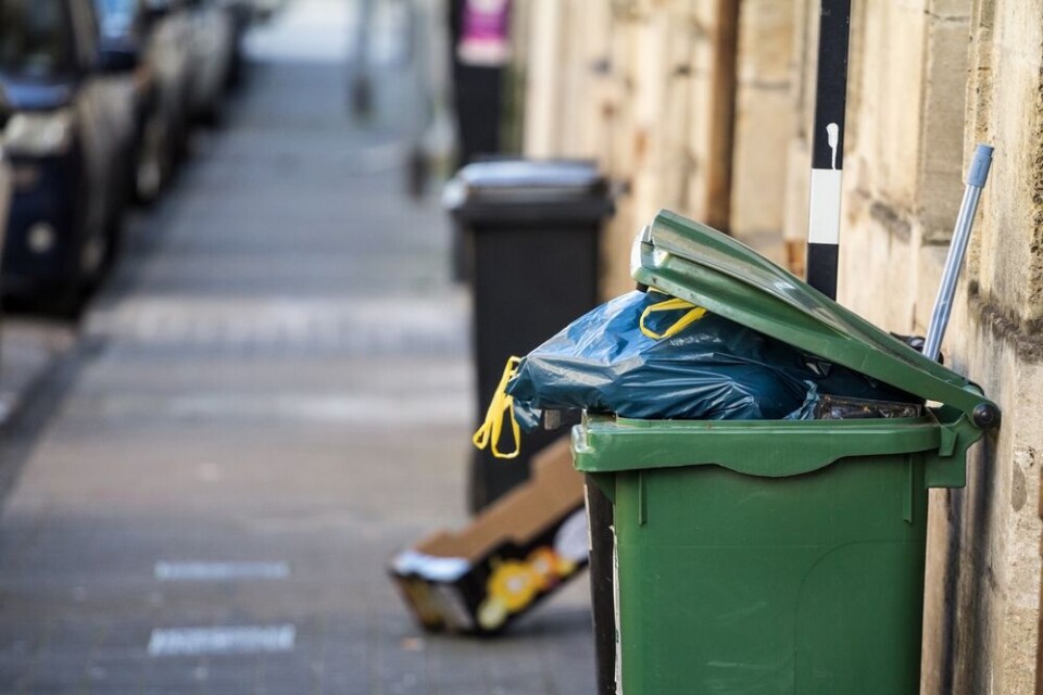 A view of an overflowing rubbish bin on a street in Bordeaux, France