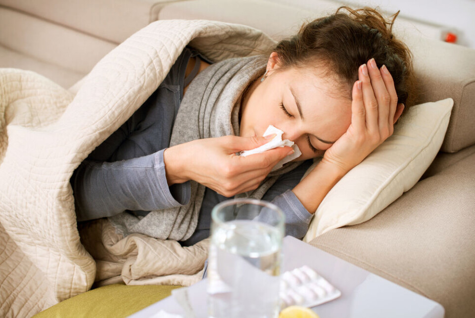 A view of an unwell woman blowing her nose