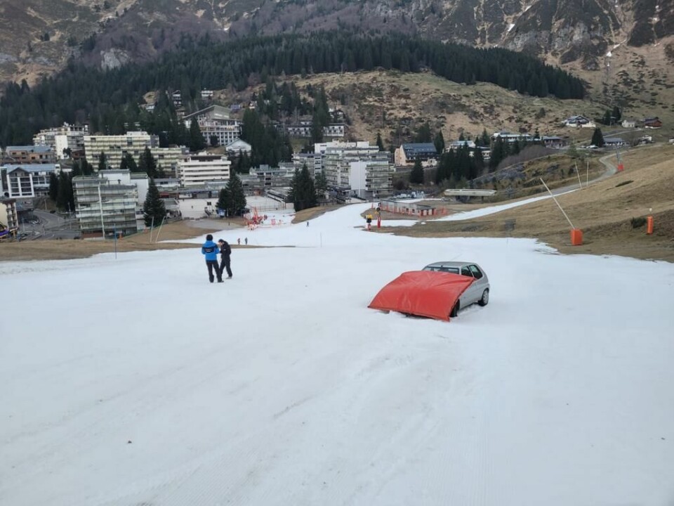 The car stuck partly up a piste with a red safety mattress placed on it