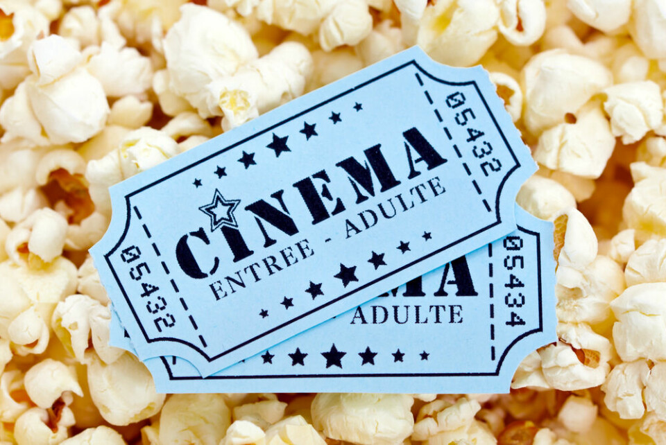 A view of two old-style cinema tickets in French, on a bed of popcorn