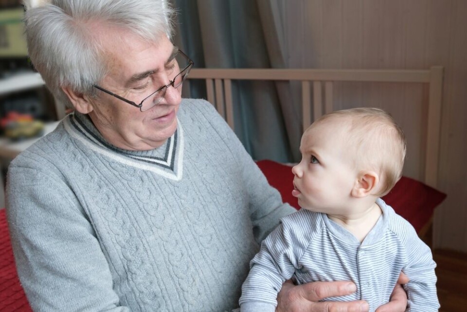 A view of an older man holding a small baby