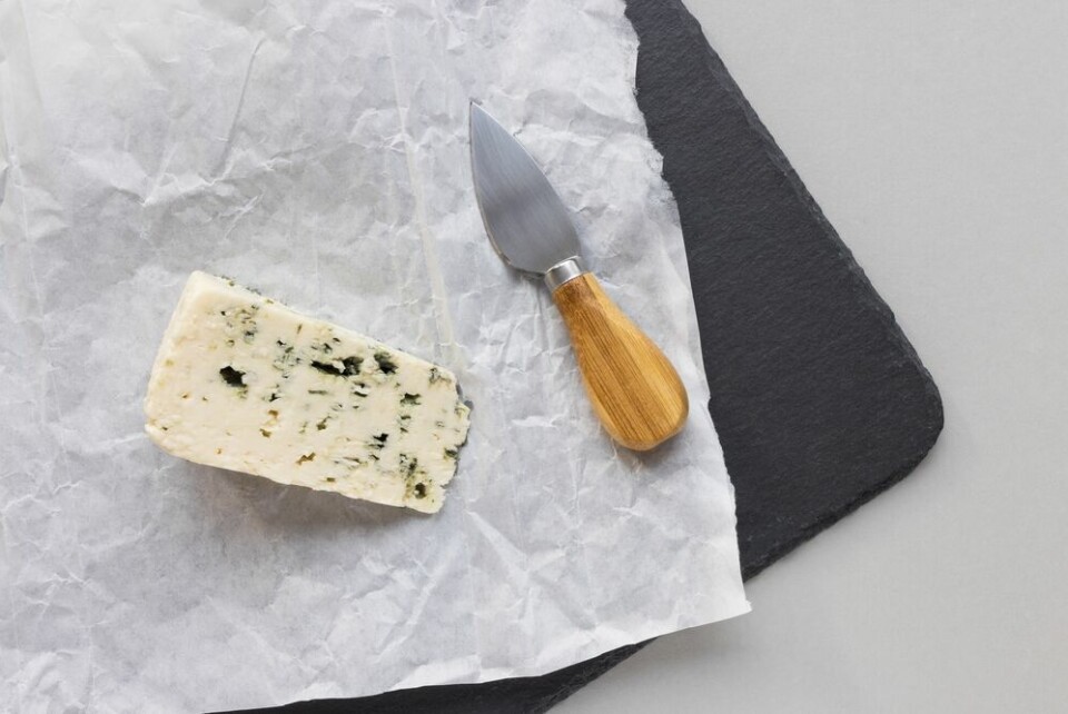 A view of a piece of Roquefort from above on a cheeseboard with a cheese knife