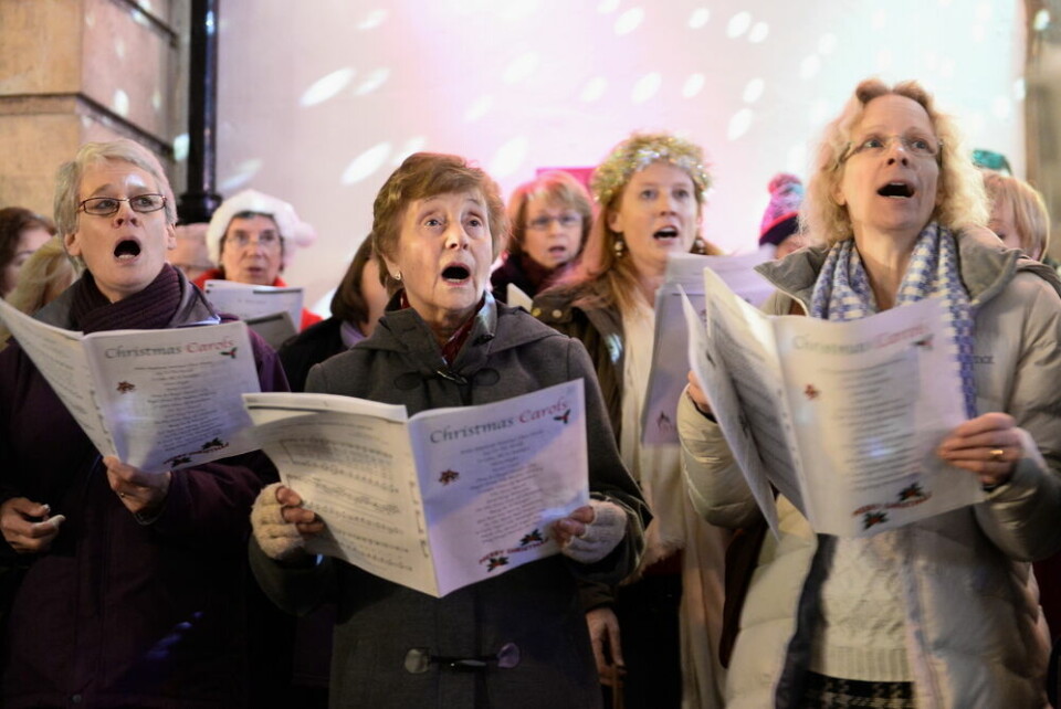 A view of a group of people singing Christmas carols