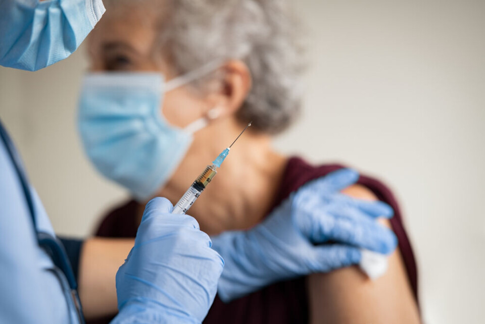 An older woman wearing a Covid mask having a vaccination