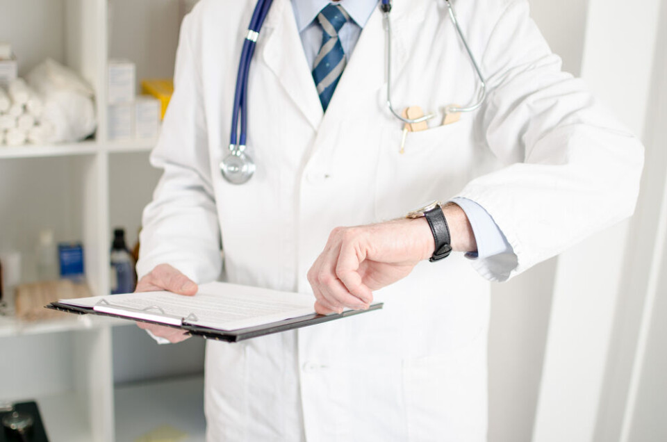 A doctor looking at his watch to show lateness and missed appointments