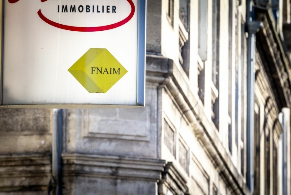 A view of an estate agent sign with the Fnaim logo in Bordeaux, France