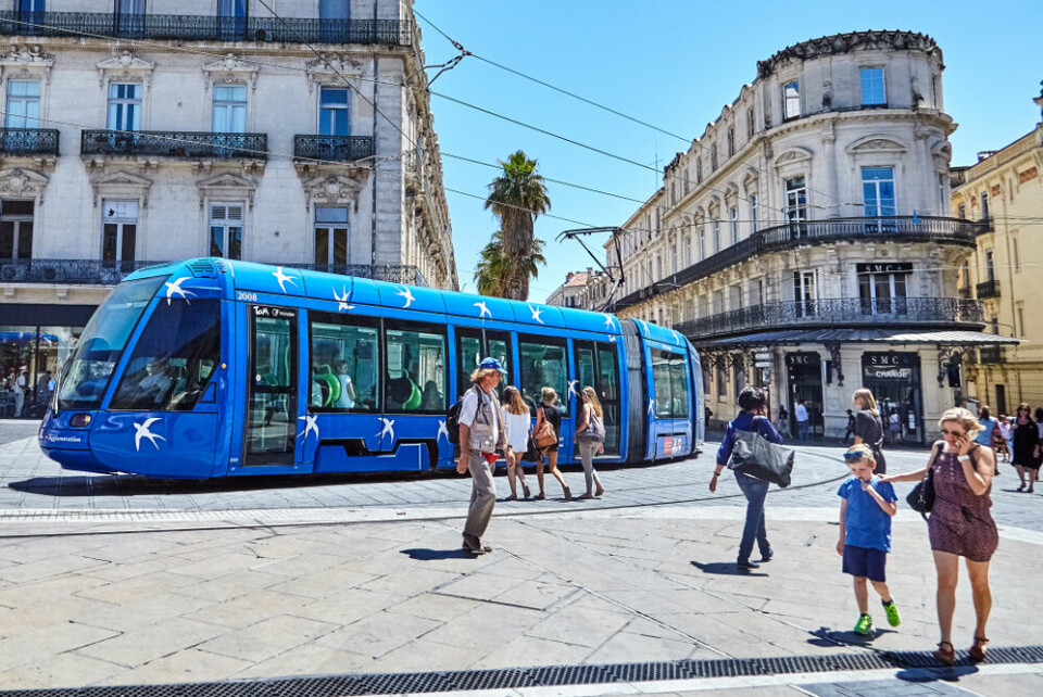 A view of a tram in Place de la Comedie, Montpellier, with pedestrians around it