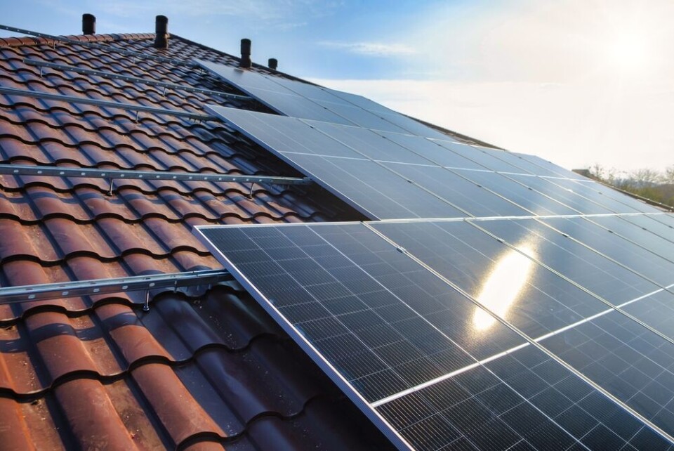 AlyoshinE / Shutterstock A view of solar panels on red tiles on a home