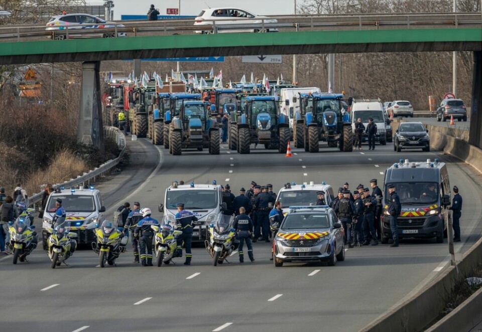 A view of the A15 motorway near Paris blockaded by tractors, flanked by police
