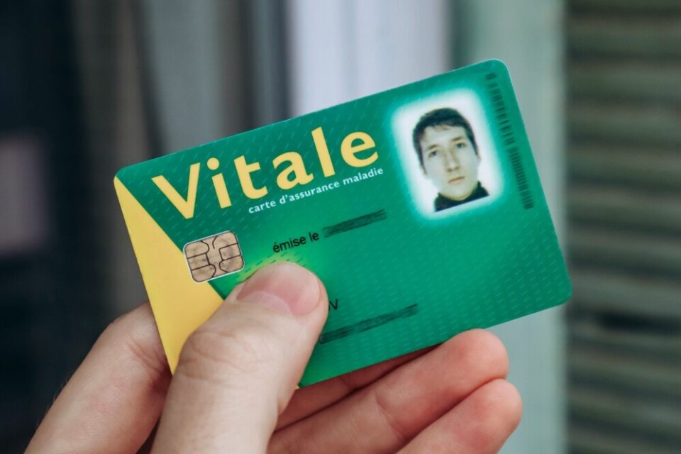 A view of someone holding out a carte Vitale (for the French health system)