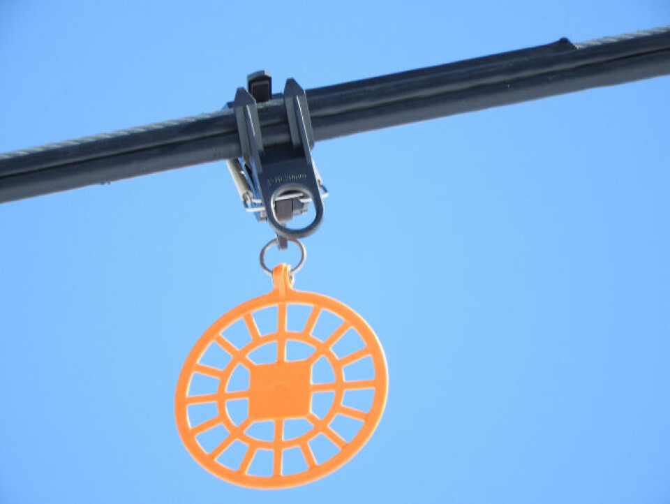 Brightly coloured disc hanging from a ski-lift cable