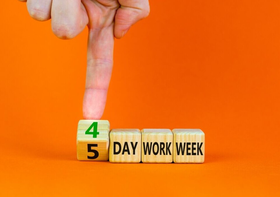A view of someone moving wooden blocks to read a ‘4’ day work week instead of ‘5’