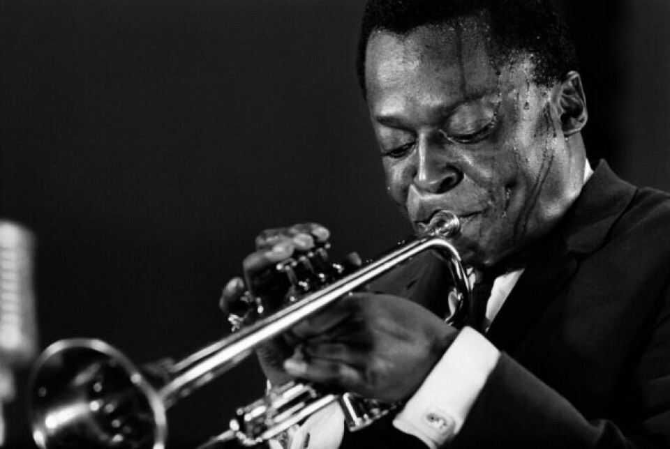 Miles Davis playing the trumpet with sweat pouring down his brow