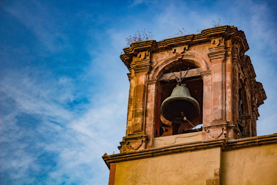 A view of a bell in an old church tower in France