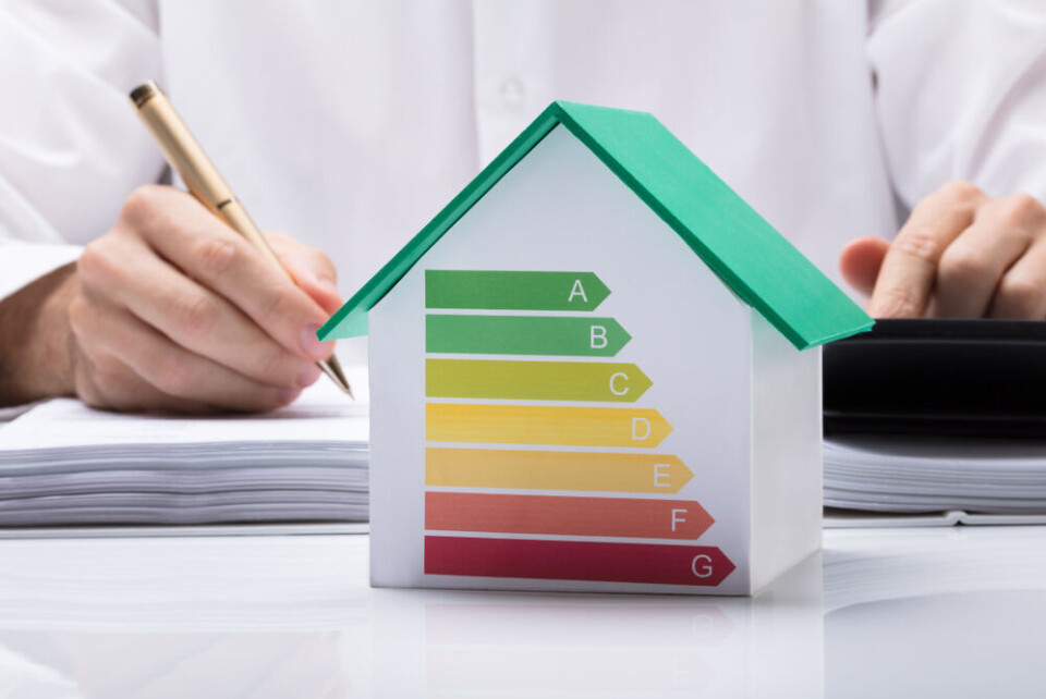 Someone calculating a house’s DPE with a model of a house and the DPE rating on it