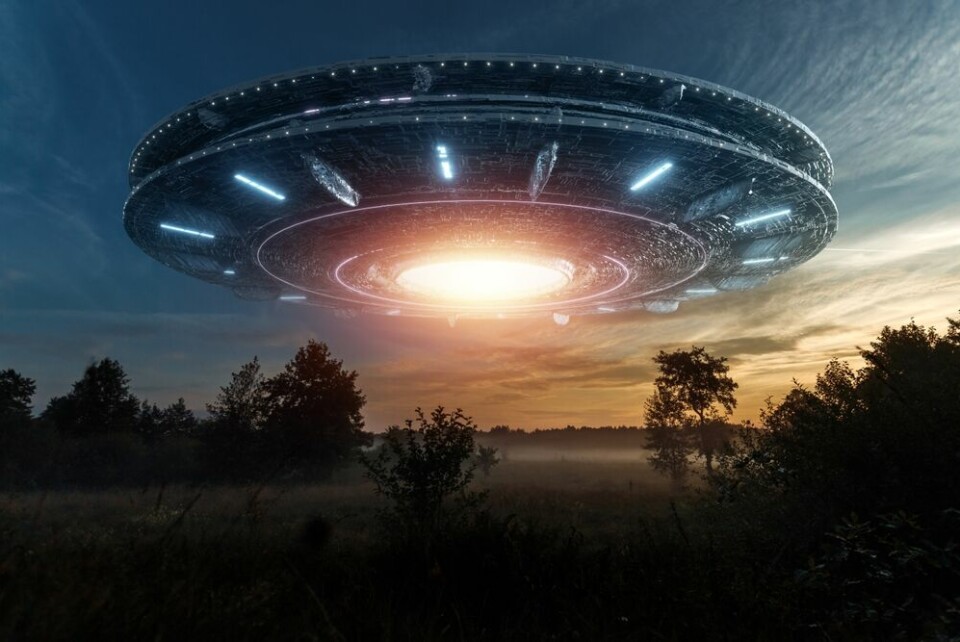A graphic showing a stereotypical idea of a spaceship hovering over fields