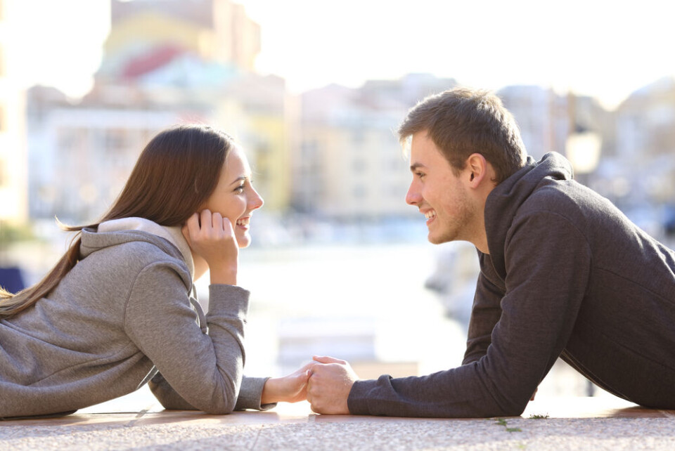 A young couple holding hands and looking into each other's eyes