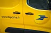 A view of a small yellow La Poste van
