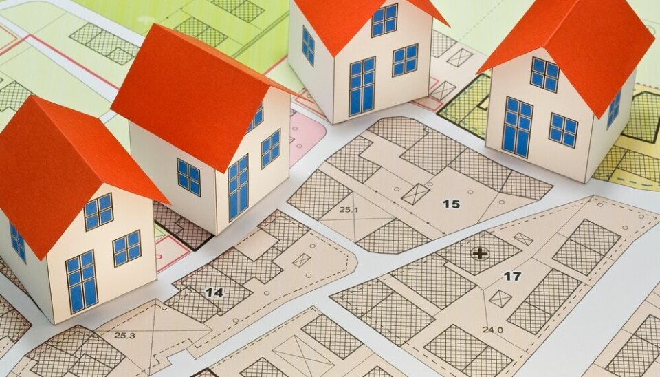 Toy houses placed on a street plan showing plots of land