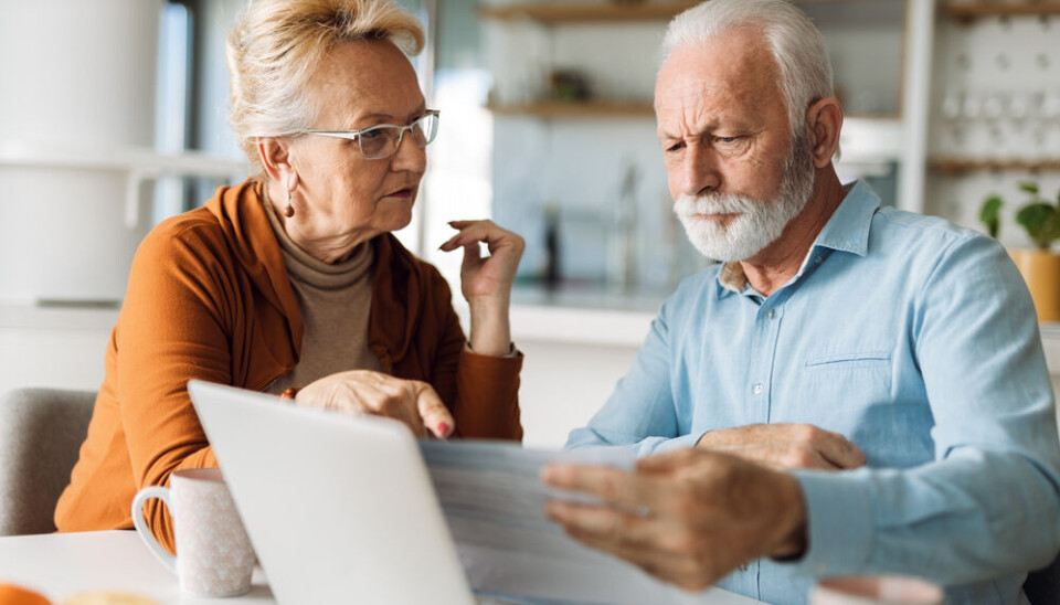 Goksi/Shutterstock Senior couple looking at paperwork in front of a laptop