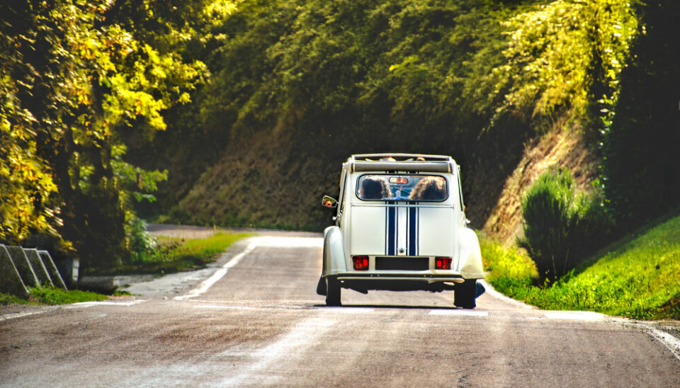 A vintage French car driving along a road