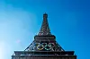 Olympic rings on Eiffel tower in paris under a clear blue sky