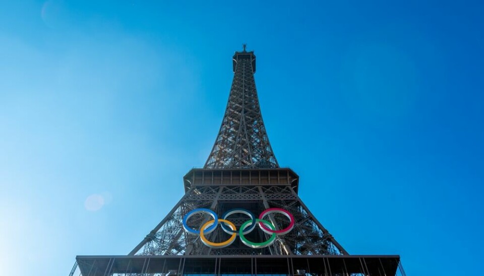 Olympic rings on Eiffel tower in paris under a clear blue sky