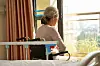 Rear view of senior asian woman sitting in wheel chair in nusing home or hospital ward in front of window