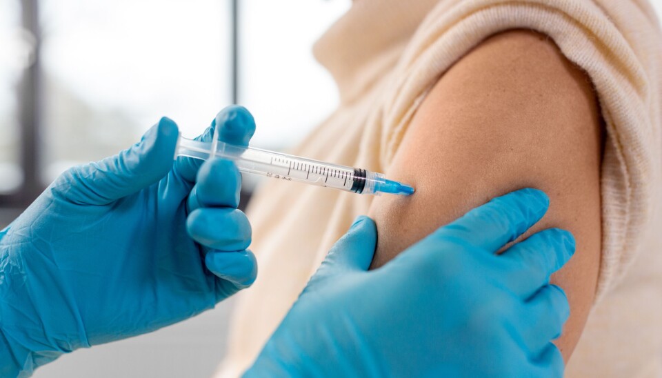 Medic administers a vaccine to the arm of a patient with a syringe