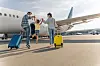 Family with luggage approach plane