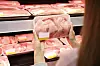 Woman holding chicken products in a supermarket