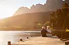 Couple sitting on a jetty at sunset