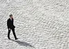 president macron of france walks across cobblestones in paris