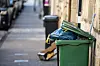A view of an overflowing rubbish bin on a street in France