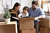 A view of a family with a child packing moving boxes